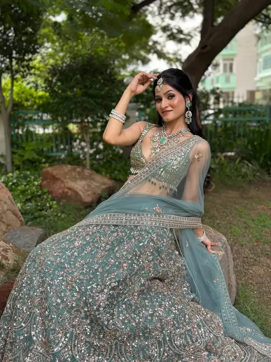 Client in a powder blue lehenga photographed outdoors