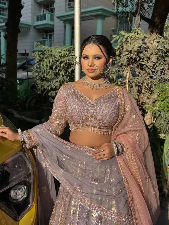 Client in a blush lehenga with a nath and layered jewellery